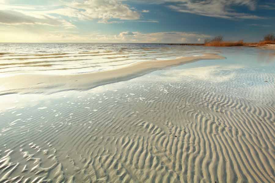 the beach at low tide with ripples in the sand