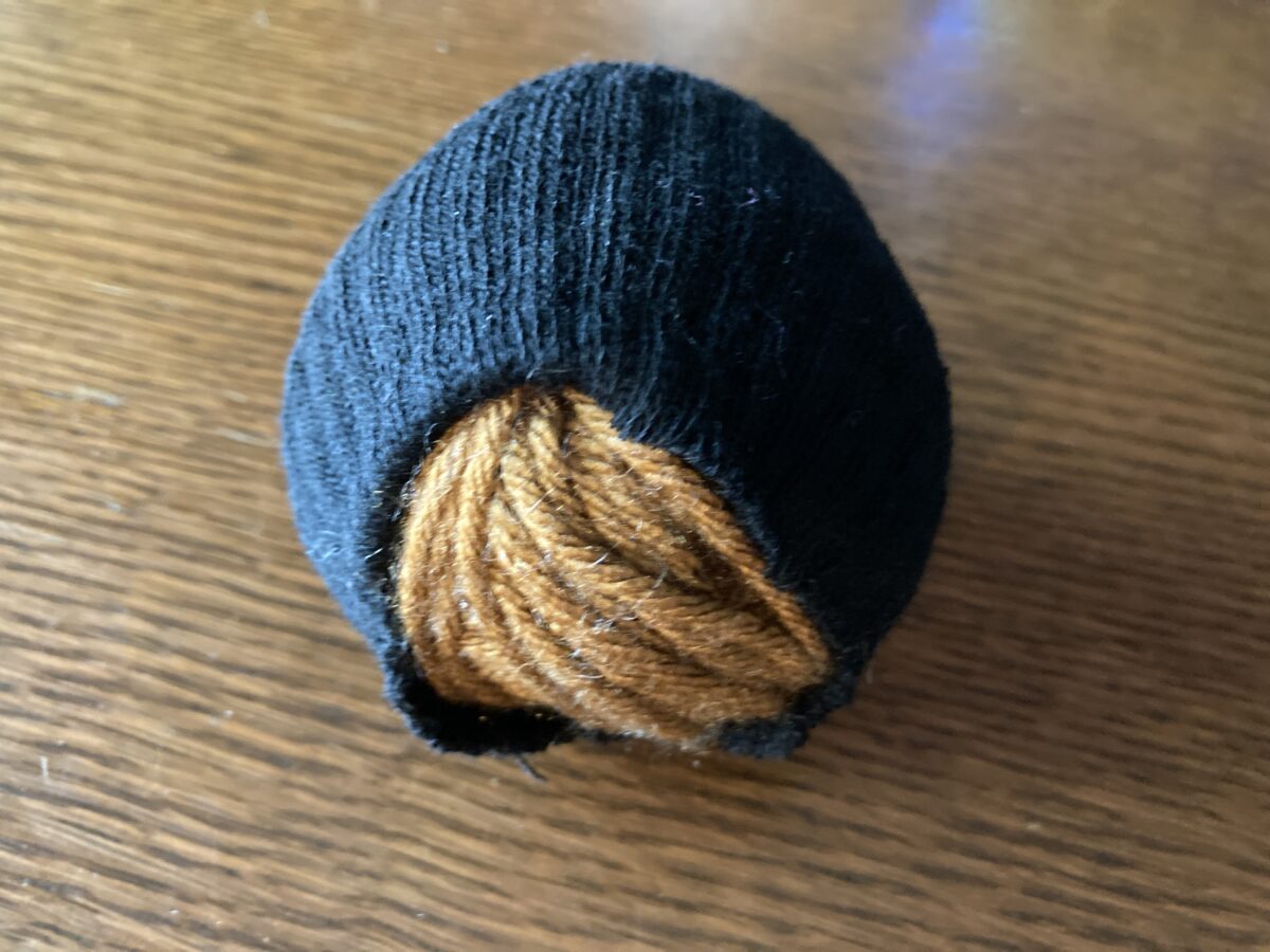 yarn ball wrapped in DIY sock yarn cozy